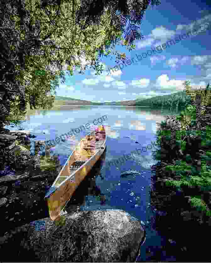 A Woman Paddles A Canoe Through A Serene Lake In The Boundary Waters Canoe Area Wilderness. The Land Beyond: A Memoir